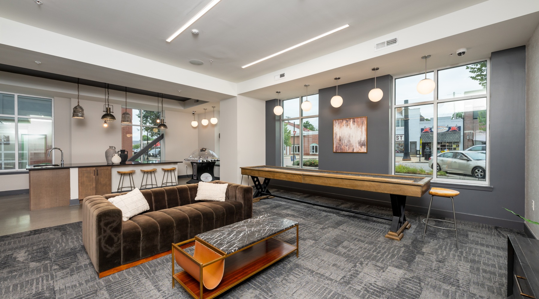 Clubhouse lounge with seating area, kitchen, and shuffleboard